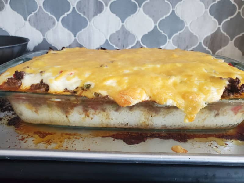 John wayne casserole with melted cheese in a casserole dish on a baking sheet