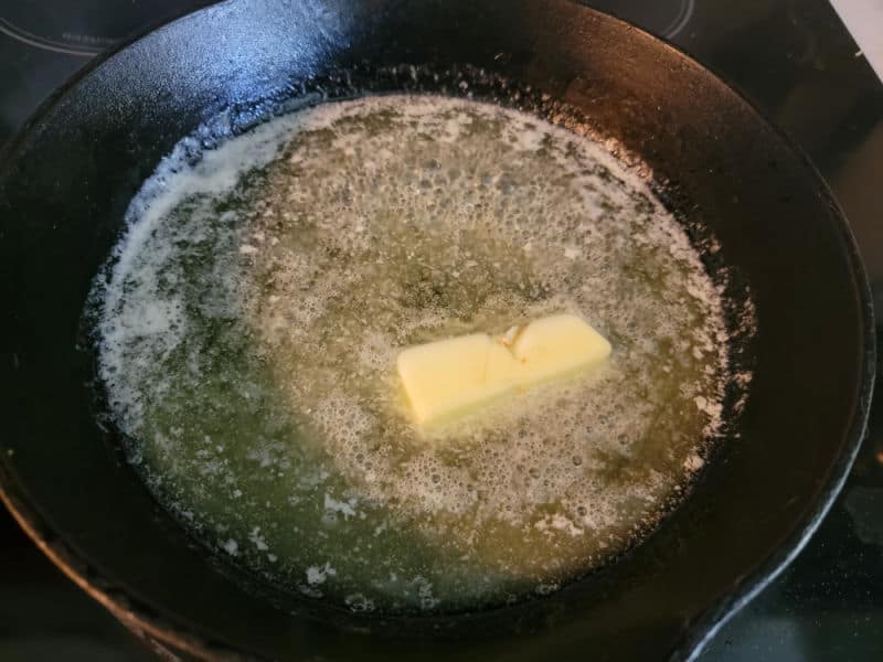 Butter melting in a cast iron skillet for a German Apple Pancake