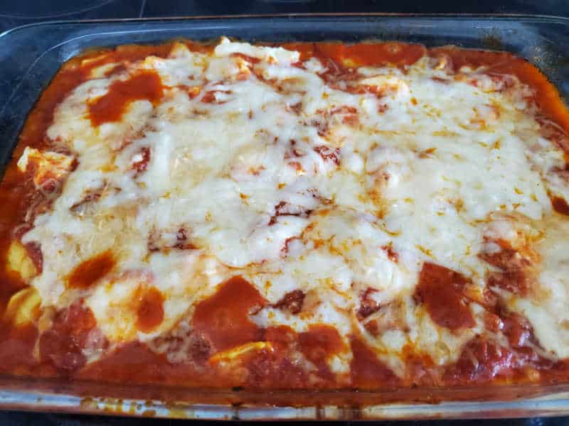 baked lazy lasagna in a glass casserole dish with melted cheese on top of it.