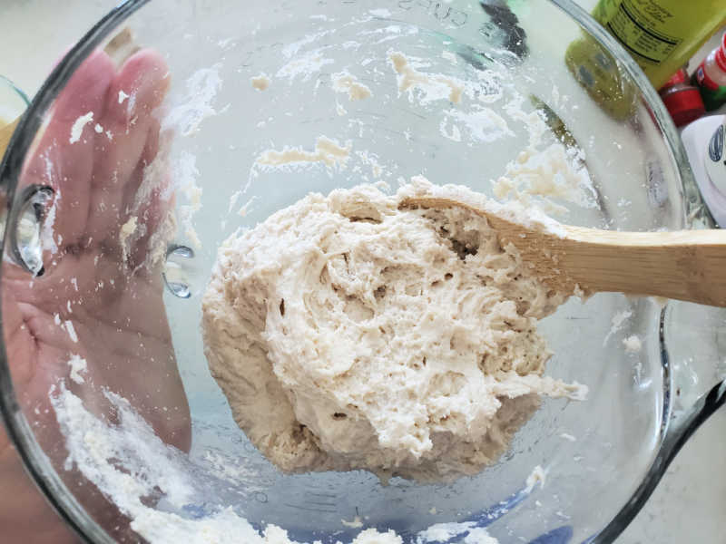 Bisquick dough ball in a glass bowl with a wooden spoon