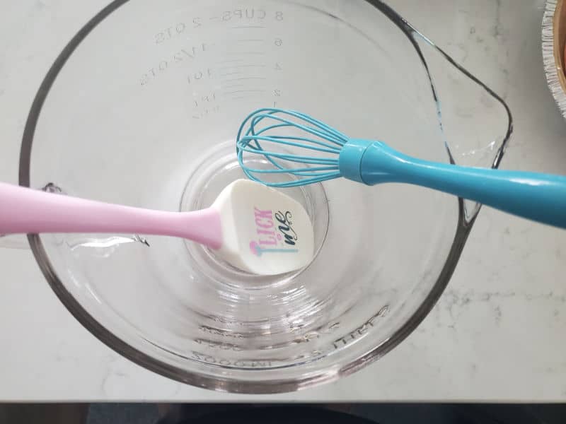 spatula and whisk in a glass bowl