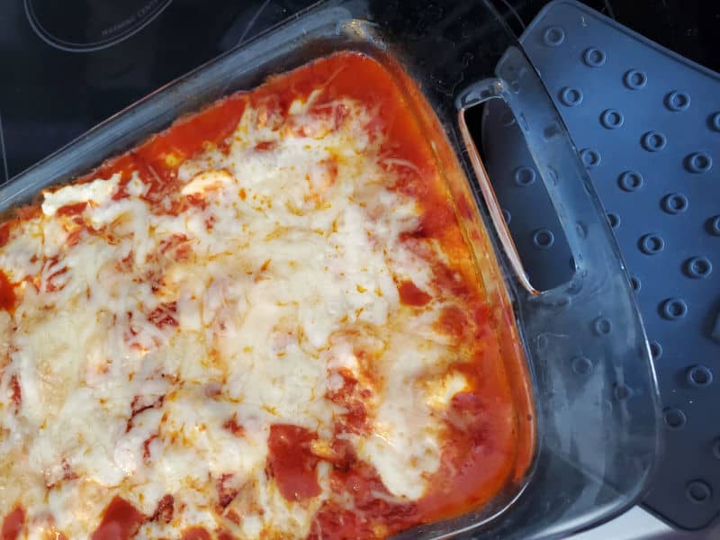 Lazy lasagna in a glass casserole dish next to a silicone oven mitt