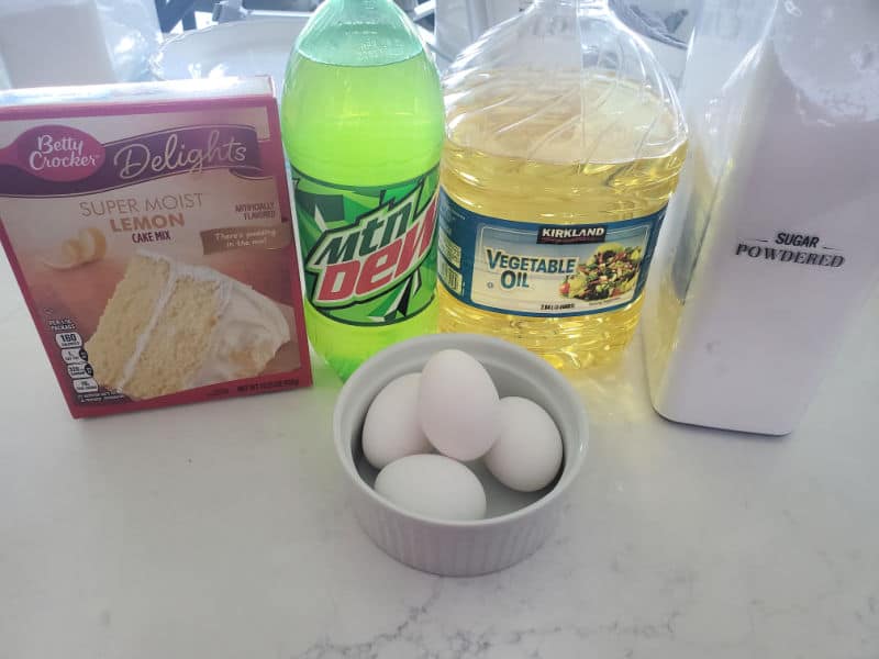 Lemon cake mix, mtns dew bottle, vegetable oil, powdered sugar, and a bowl of eggs