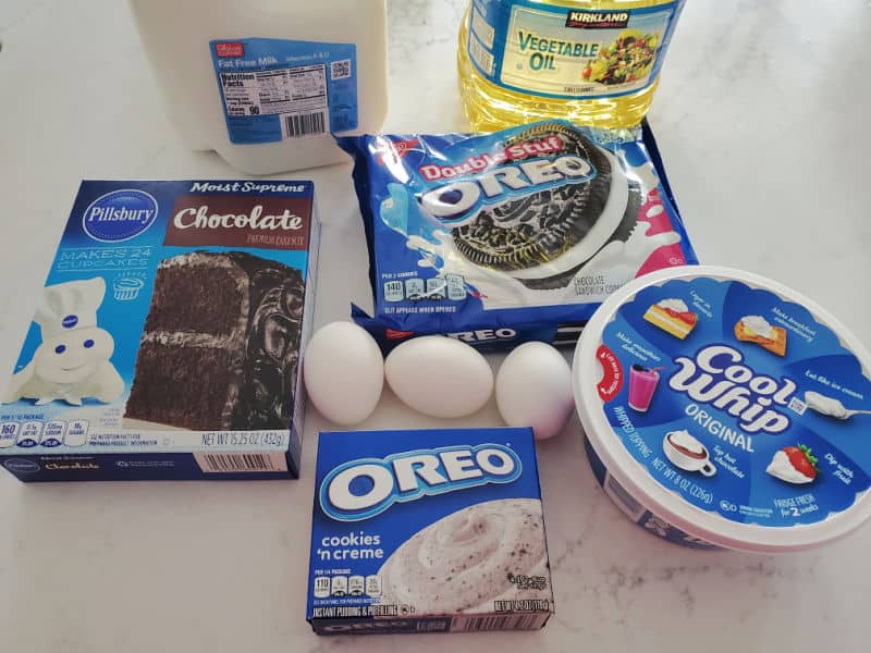milk, vegetable oil, cake mix, Double Stuff Oreos, eggs, Oreo pudding, and cool whip on a white counter. 