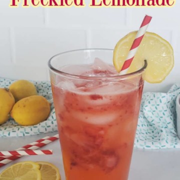 Red Robin Freckled Lemonade text printed over a glass filled with strawberry lemonade and a lemon wheel