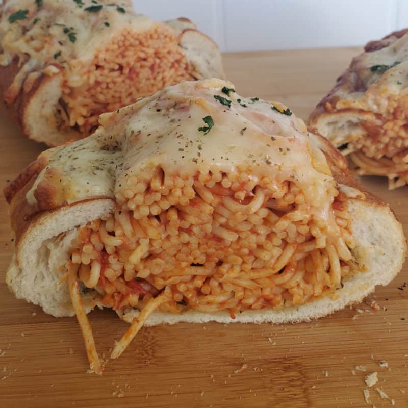 Spaghetti Stuffed Garlic Bread on a wood cutting board