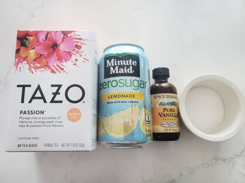 Tazo Passion Tea box, Minute Maid Zero Sugar, pure vanilla, and sugar on a white counter