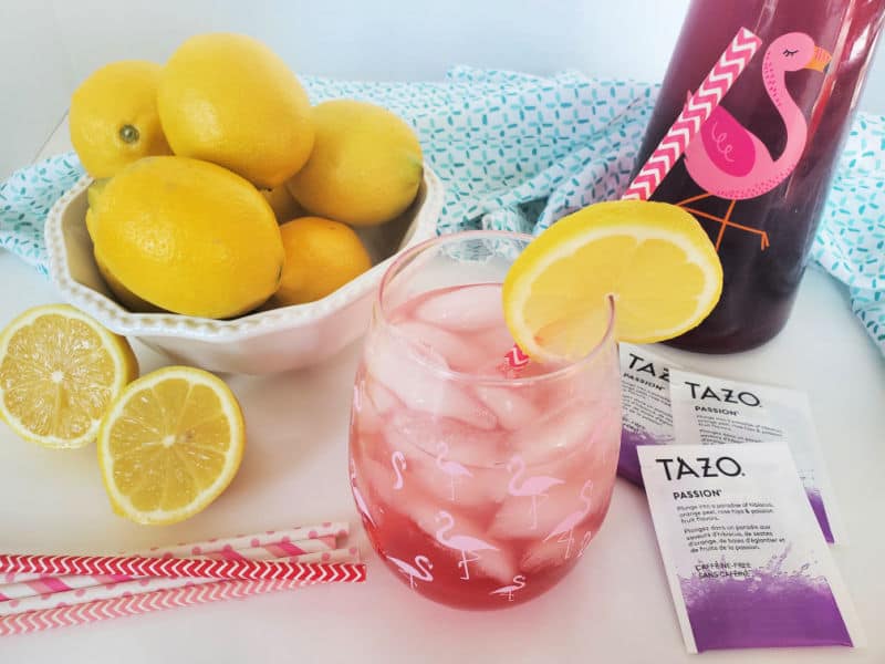 Copycat Starbucks Passion Tea Lemonade in a mason jar next to Tazo Passion tea bags, and a bowl of lemons