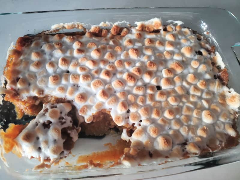 sweet potato casserole with mini marshmallows in a glass casserole baking dish