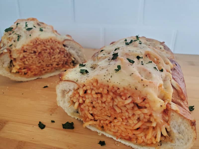 Spaghetti Stuffed Garlic Bread on a wood cutting board