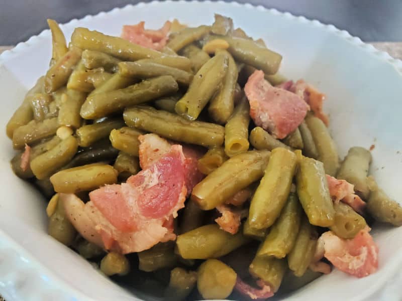 southern style green beans and bacon in a white serving bowl