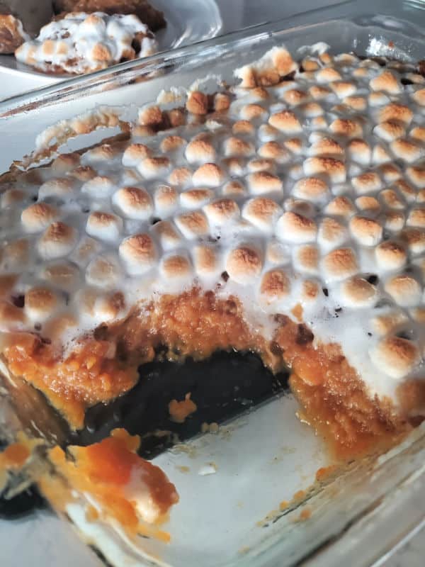 mashed sweet potatoes topped with toasted mini marshmallows in a glass casserole dish