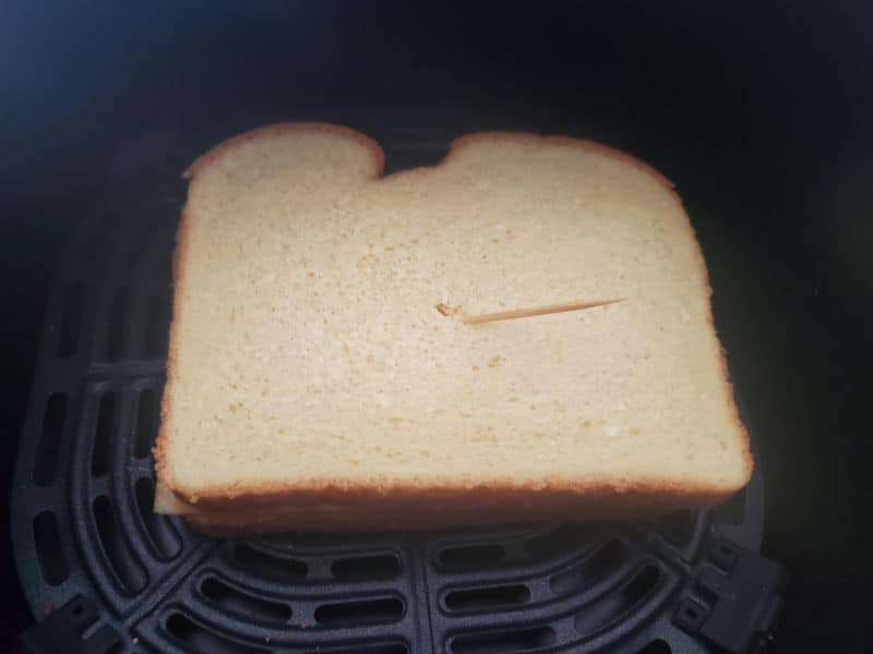 bread in an air fryer basket held together with a toothpick