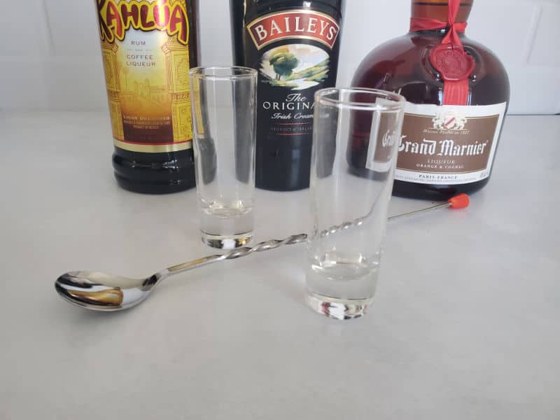 Kahlua, Baileys Irish Cream, Grand Marnier, two shot glasses and a bartending spoon to make a B52 shot