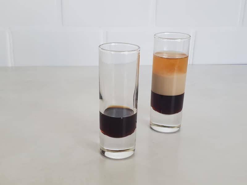 Kahlua layer poured in one glass and a complete B52 Layered Shot in the other glass