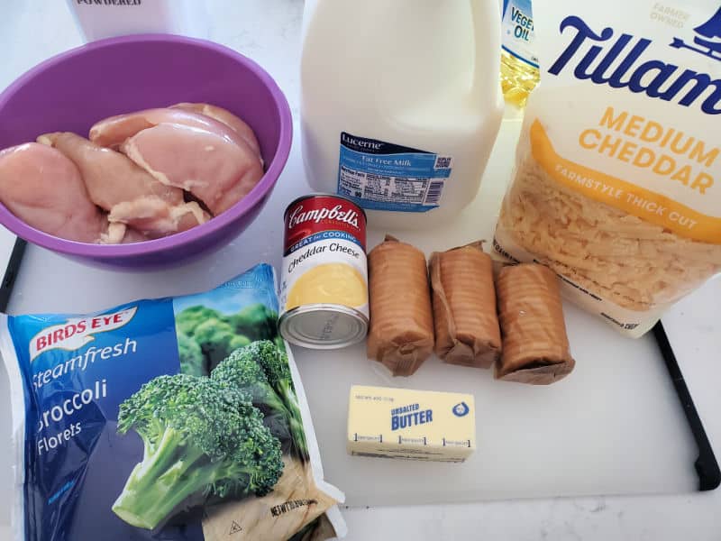 chicken breast in a purple bowl, milk, cheddar cheese, broccoli, cheddar cheese soup, butter, and ritz crackers