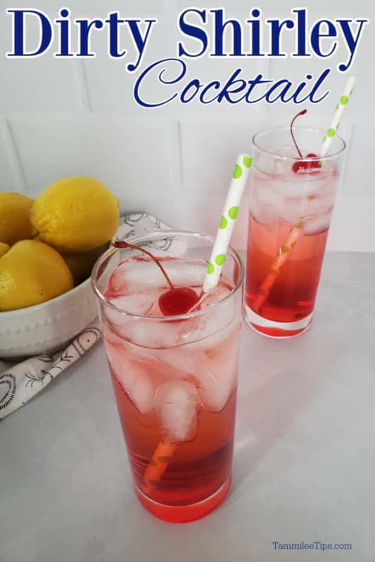 two glasses with Dirty Shirley Cocktails garnished with maraschino cherries by a bowl of lemons