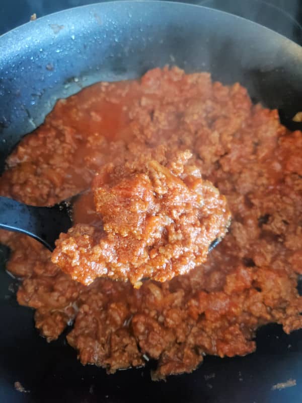 spoon holding ground beef mixture over a skillet