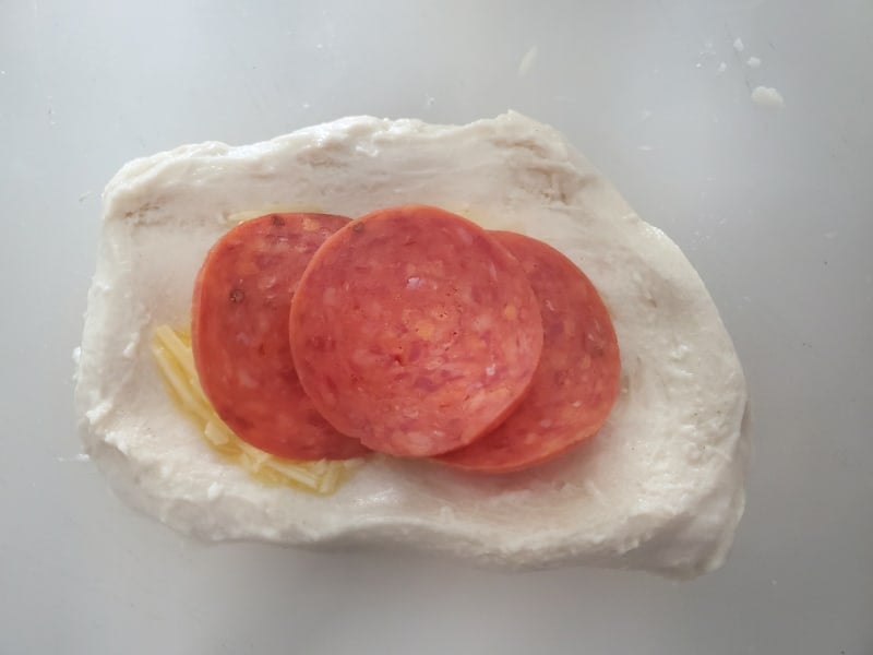 pepperoni slices on top of bread dough