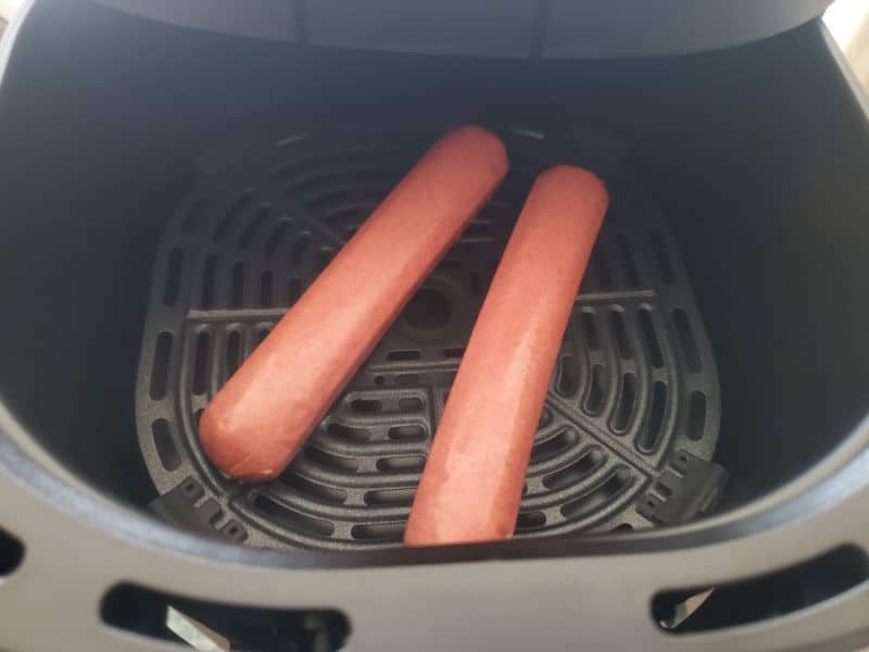 two hot dogs in an air fryer basket