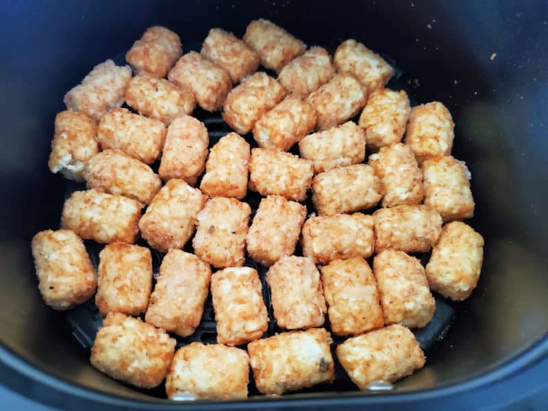 frozen tater tots in air fryer basket before cooking