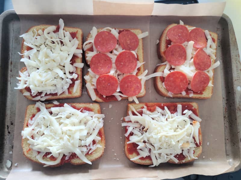 uncooked pizza toast arranged on a parchment lined baking sheet