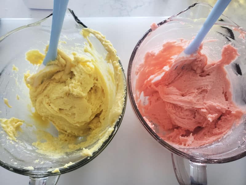 lemon cake cookie batter and strawberry cake cookie batter in glass bowls with spatulas 