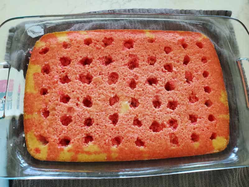 Red poured over the white cake in a baking dish