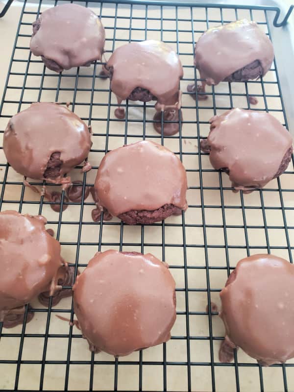 Texas sheet cake cookies with chocolate icing over the top of them on a drying rack