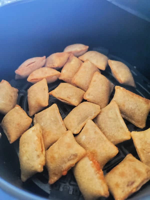 Air fryer pizza rolls in the air fryer basket. 