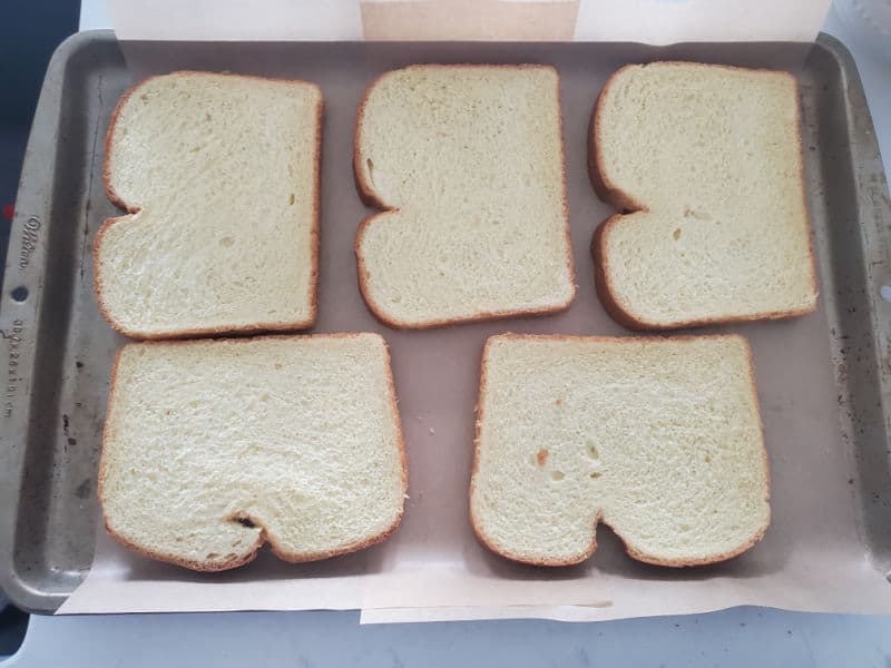 bread slices arranged on a parchment lined baking sheet