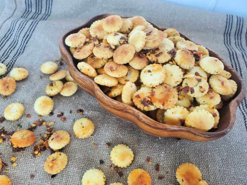 spicy oyster crackers in a wooden bowl on a burlap cloth