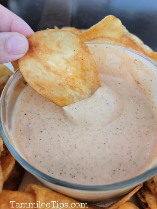 Potato chip dipping into Zax's Sauce in a glass bowl