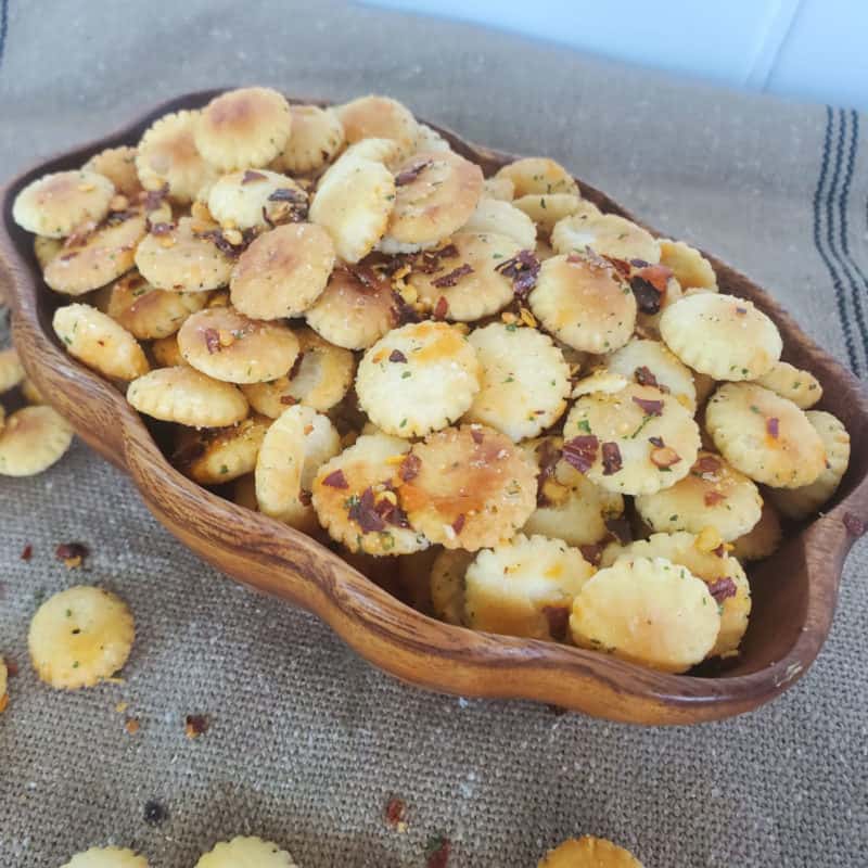 spicy oyster crackers in a wooden bowl on a burlap cloth