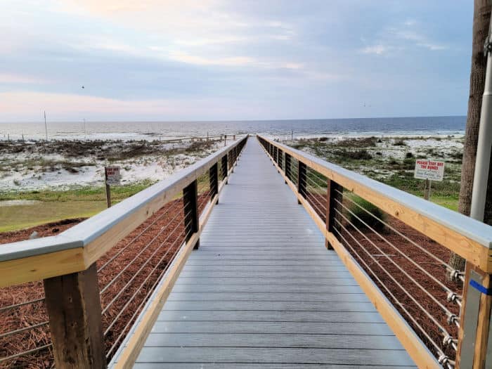Wooden boardwalk over the sand dunes to the Gulf of Mexico in the distance. 