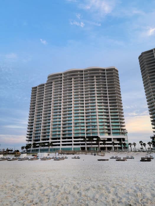 Turquoise Place condo complex from the sand with beach chairs in front of it