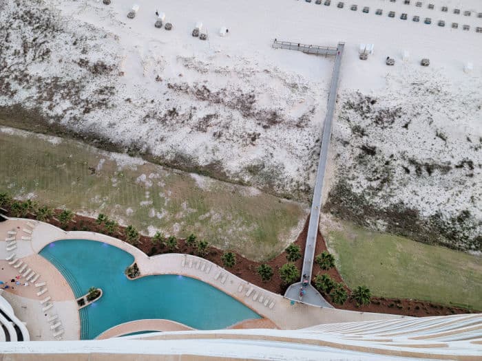 Looking down to the pool, wooden boardwalk over the sand dunes, and white sand