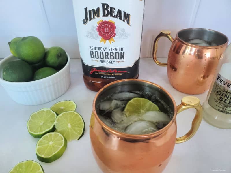 Kentucky Mule Cocktail in a copper mug next to a bottle of Jim Beam