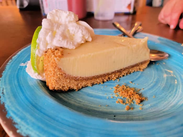 Key Lime pie with whipped cream garnish on a turquoise plate
