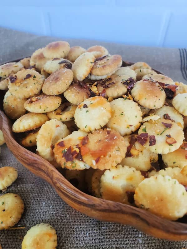 spicy oyster crackers in a wooden bowl on a burlap cloth