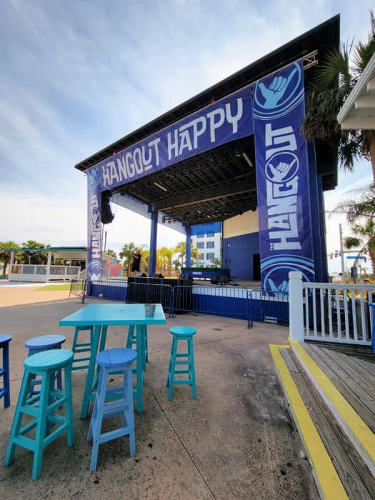 Hangout Happy on an outdoor stage with tables and chairs