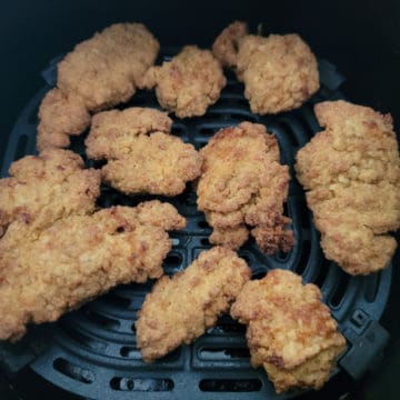 air fried chicken nuggets spread in an air fryer basket