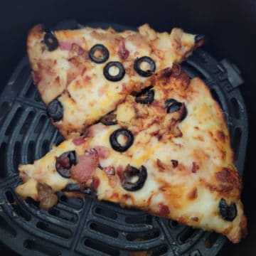 two slices of leftover pizza in the air fryer basket