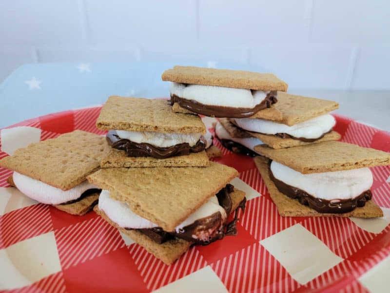 Oven smores on a red checkerboard paper plate with a blue star napkin