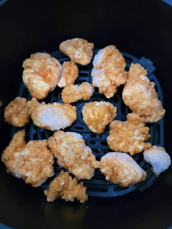 Frozen popcorn chicken in an air fryer basket