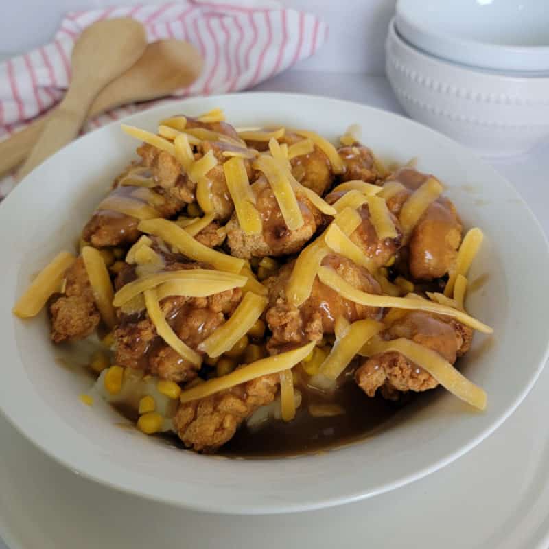 KFC Famous Bowl in a white bowl by wooden spoons