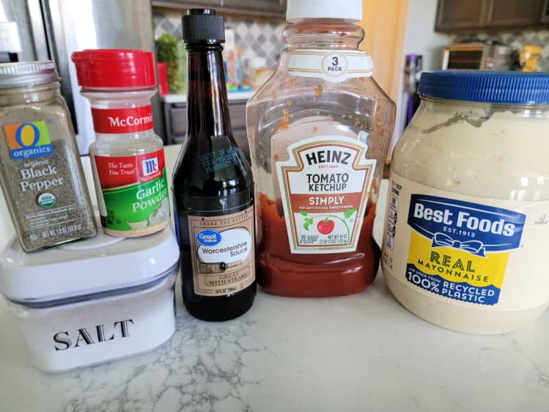 black pepper, garlic powder, salt, Worcestershire sauce, ketchup, and mayo on a white counter. 