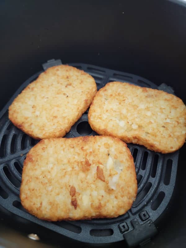 air fried hashbrown patties in an air fryer basket