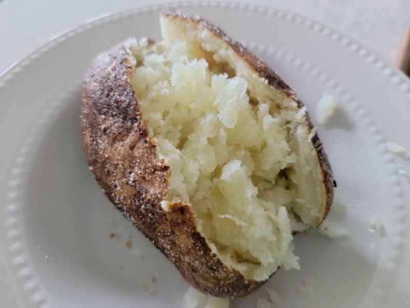 potato split open on a white plate