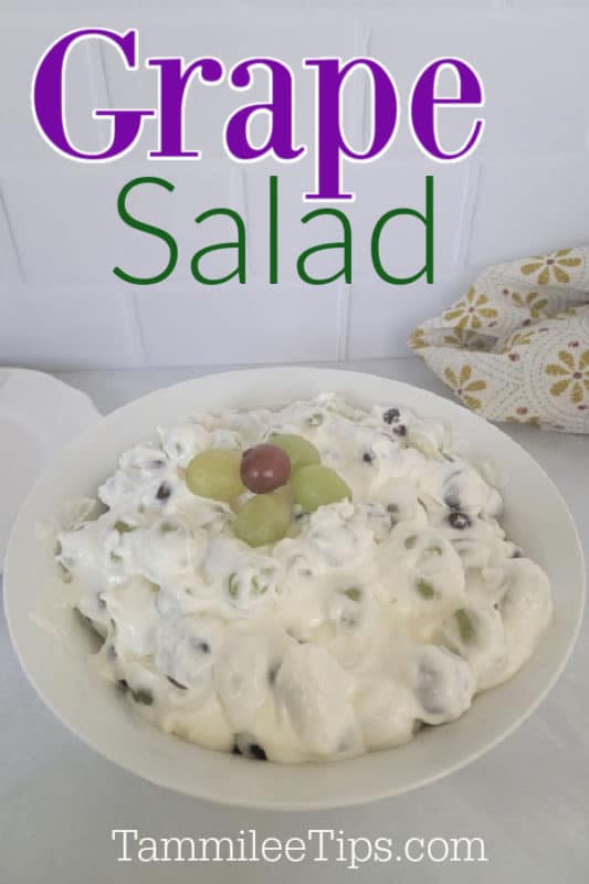 Grape Salad over a white bowl with grapes next to a cloth napkin